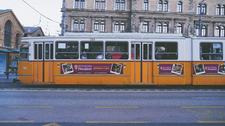 Classic yellow tram in Budapest, Hungary passing through the city’s historic streets near the Central Market Hall — a charming European destination to visit in December