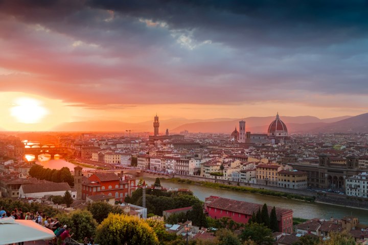 Breathtaking sunset view of Florence, Italy featuring the iconic Florence Cathedral (Duomo), Arno River, and historic skyline