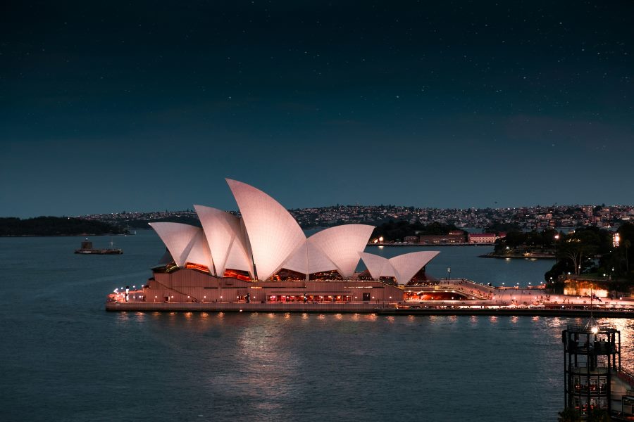 Sydney Opera House illuminated at night with city lights reflecting on the harbor—highlighting Australia as one of the best countries to visit in December for summer festivities and waterfront experiences.