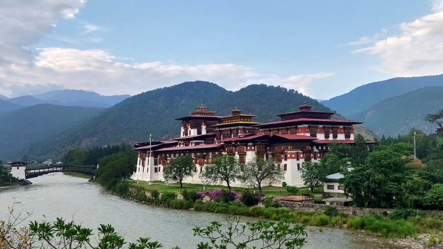 Punakha Dzong, a majestic riverside fortress with traditional Bhutanese architecture, surrounded by lush greenery and mountains in Bhutan.
